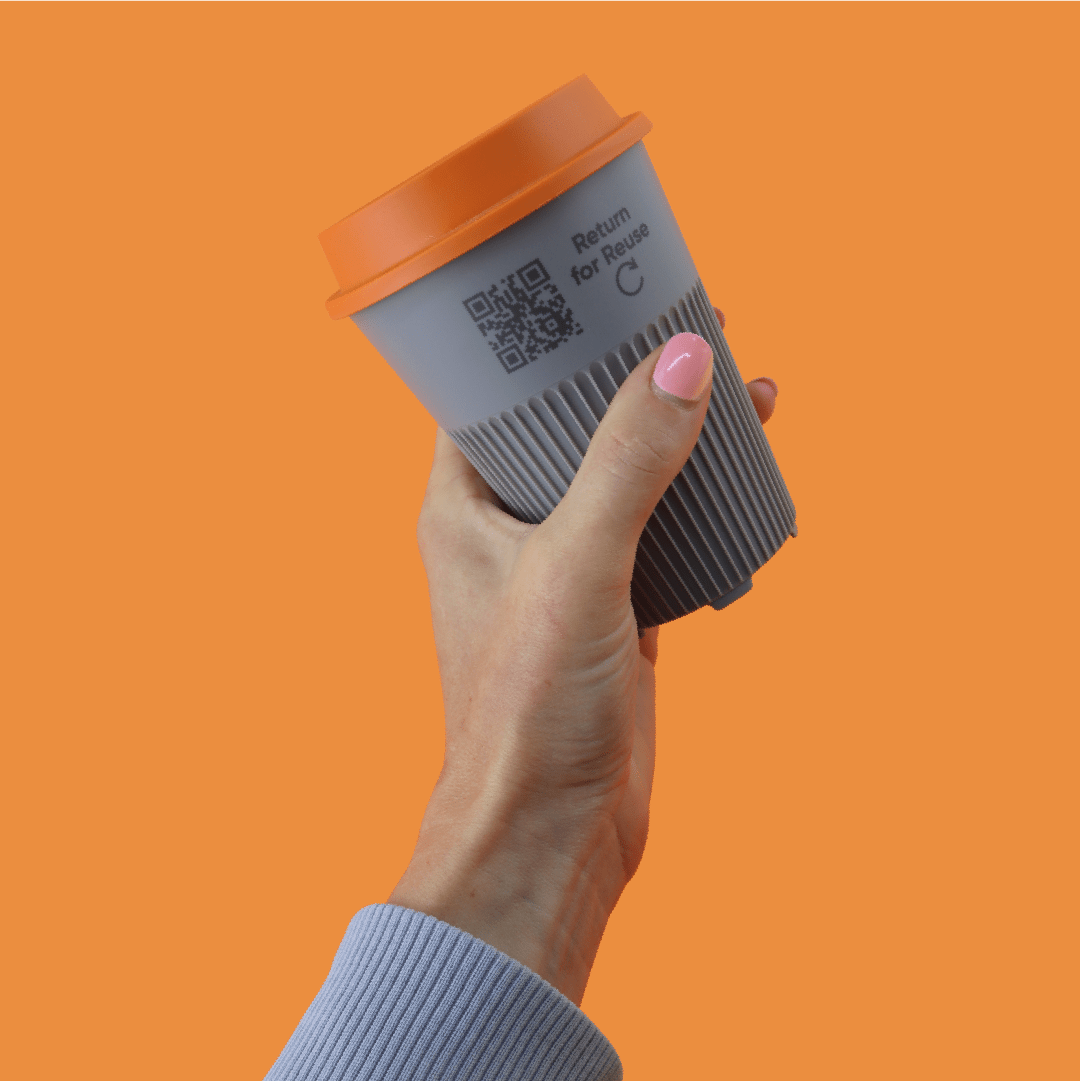 tap&reuse returnable cup with QR code being held by hand on orange background