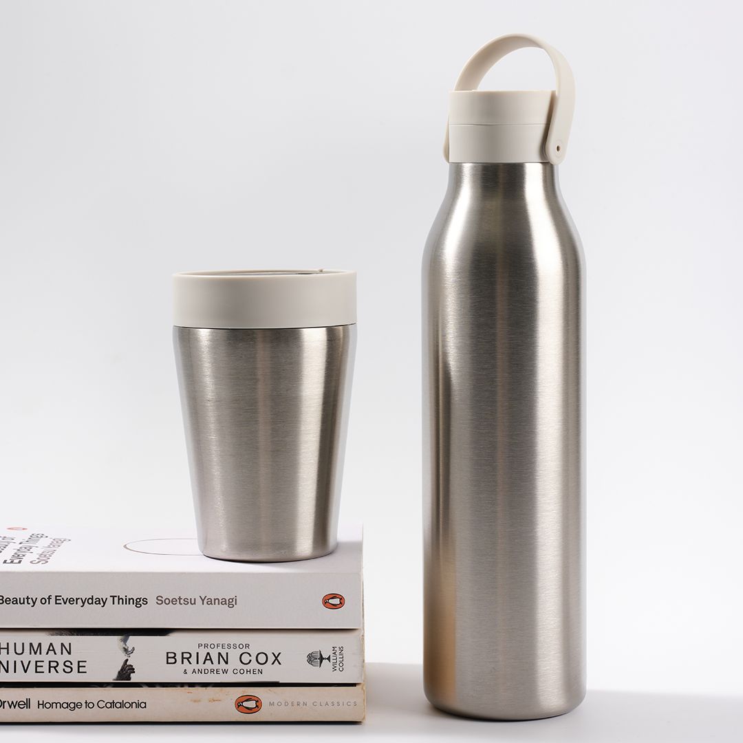 8oz Stainless Steel reusable Travel Mug with pebble white lid and 500ml stainless steel Reusable Water Bottle with pebble white lid Bundle on a set of books